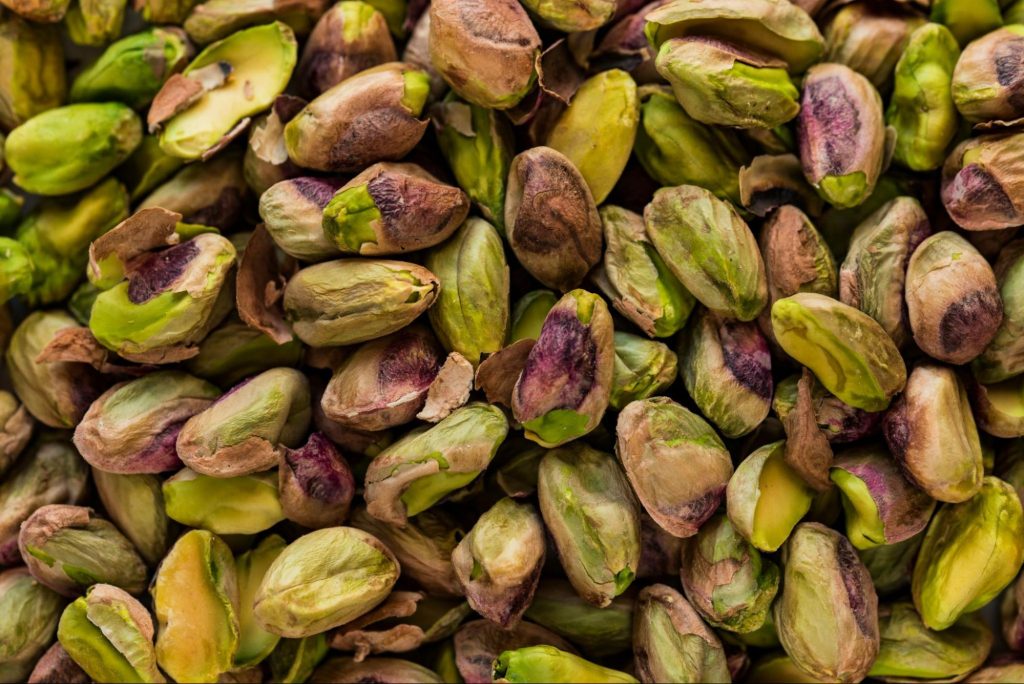 Close-up of raw pistachios with green and purple tones
