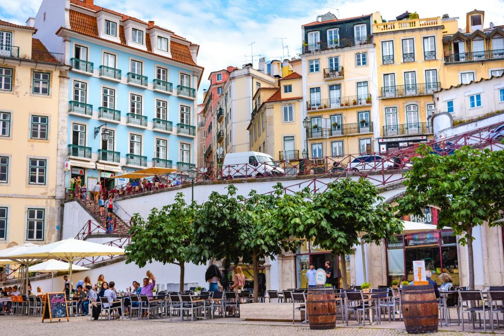Outdoor café terraces beneath colorful Lisbon buildings