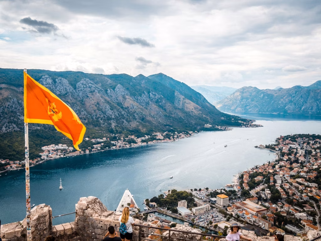 View over the Bay of Kotor from the fortress with a Montenegro flag in the foreground