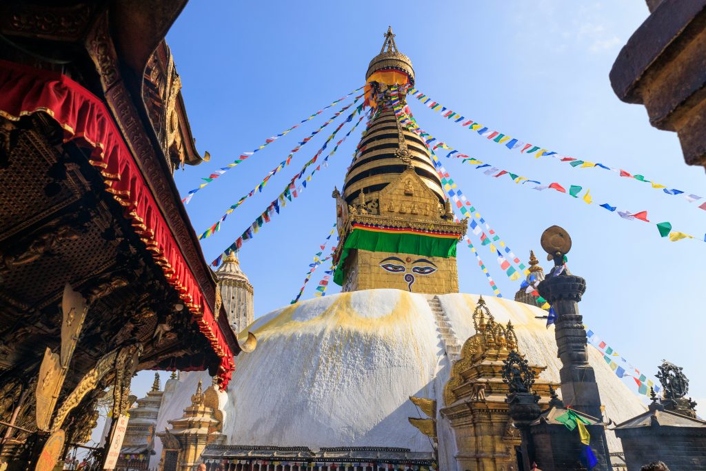 Swayambhunath Stupa in Kathmandu with Buddha eyes and prayer flags.