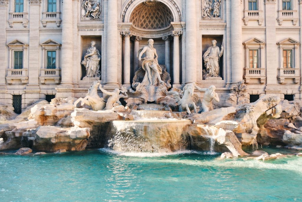 Trevi Fountain in Rome with turquoise water, marble statues, and the ornate historic façade behind it